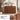 A medium brown wooden credenza or sideboard with a sculptural arched panel design on the front, shown in a styled interior room. The image includes a bottom text panel explaining the artistic arch design and two detail callouts showing the layered wood grain.