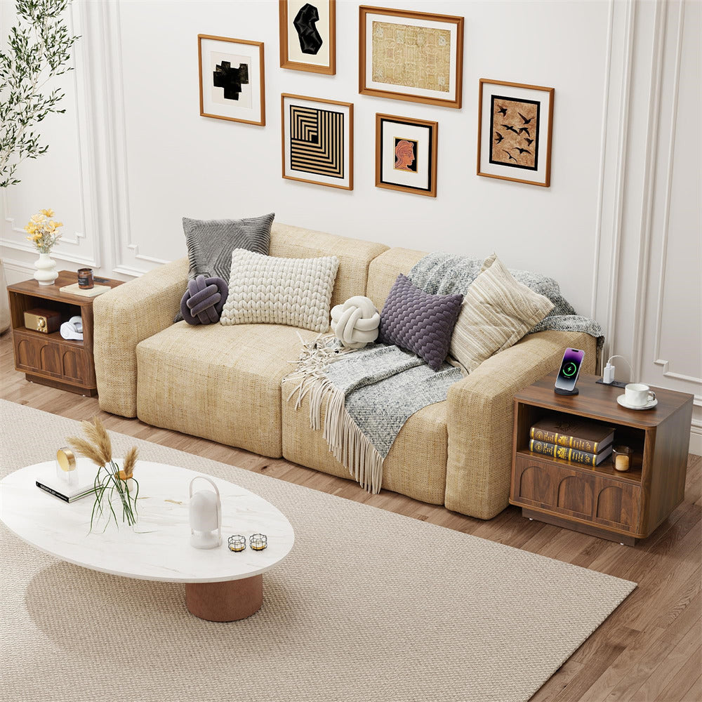 Living room with beige sofa, wooden side tables, and decorative items.