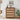 Wooden dresser with woven drawers in a room setting with decor elements.