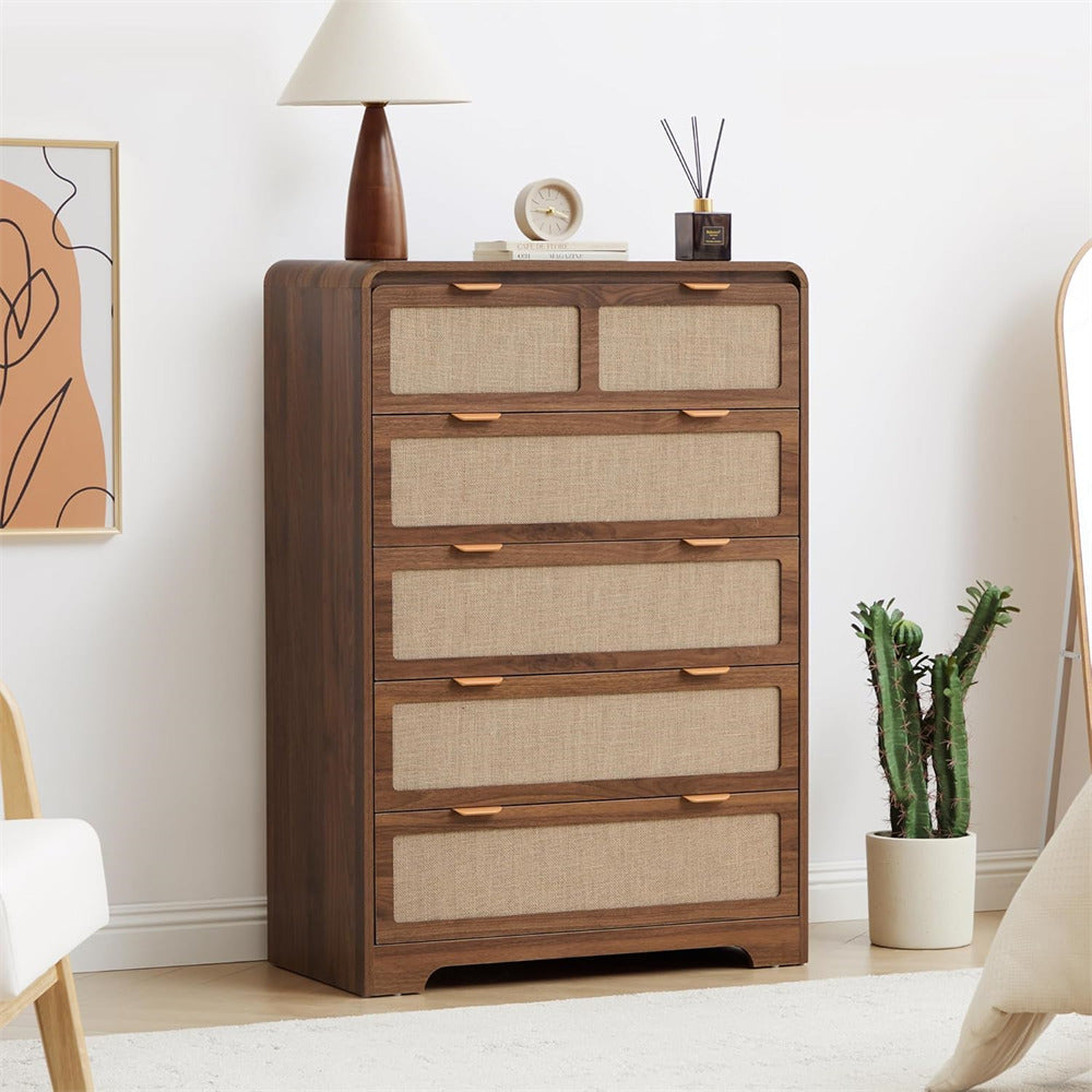 Wooden 5 drawer dressers with fabric panels and brass handles in a room setting.