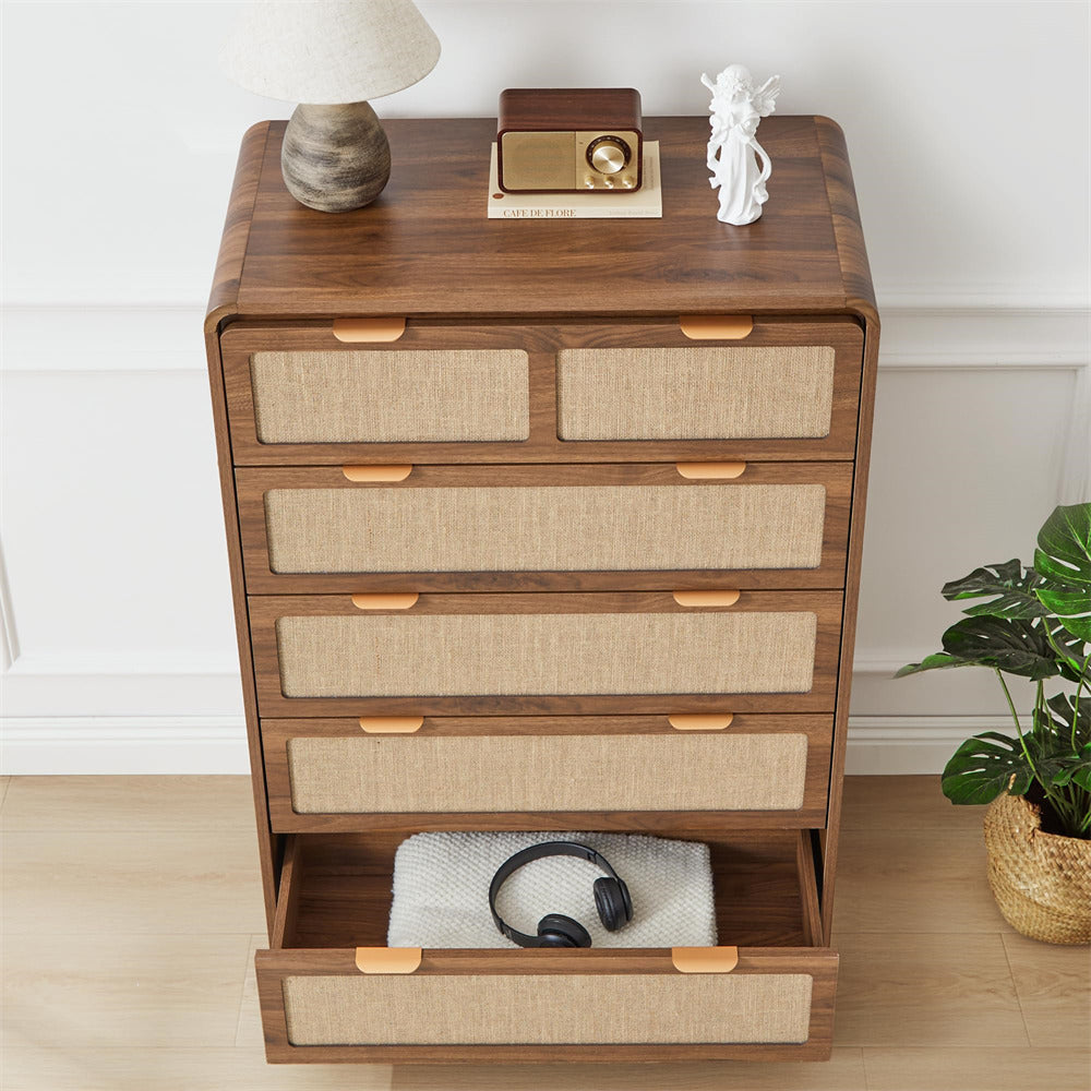 Wooden dresser with fabric drawers in a room setting with a plant and decor items.