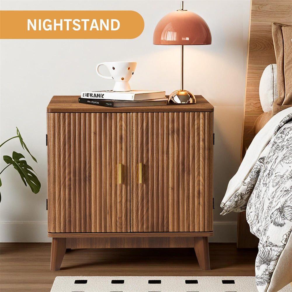 Wooden nightstand with a lamp and books next to a bed