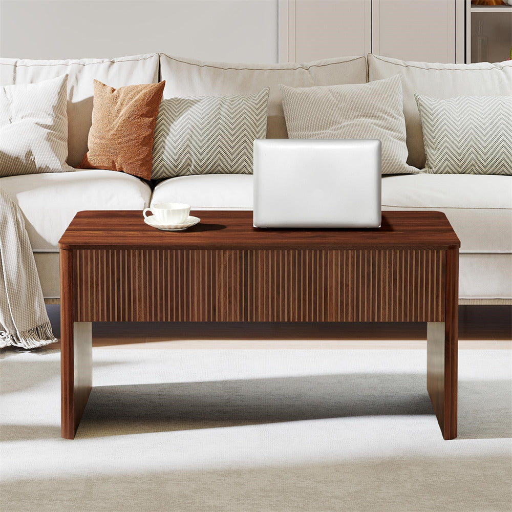 Wooden coffee table with a laptop and cup in front of a beige sofa with patterned cushions.
