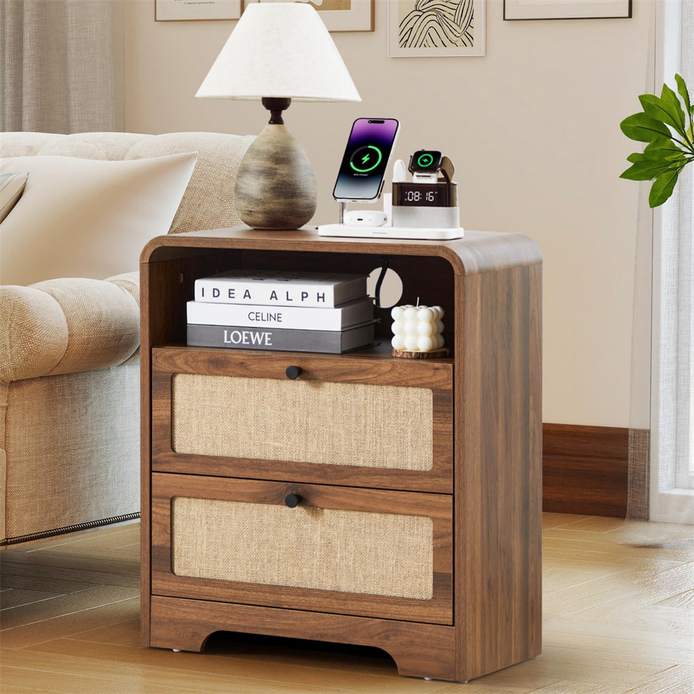 Wooden nightstand with books, a lamp, and electronic devices in a living room setting.
