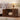 Wooden pet enclosure for a cat in a living room setting with a lamp and books.