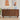 Wooden sideboard with decorative items in a room with abstract wall art.