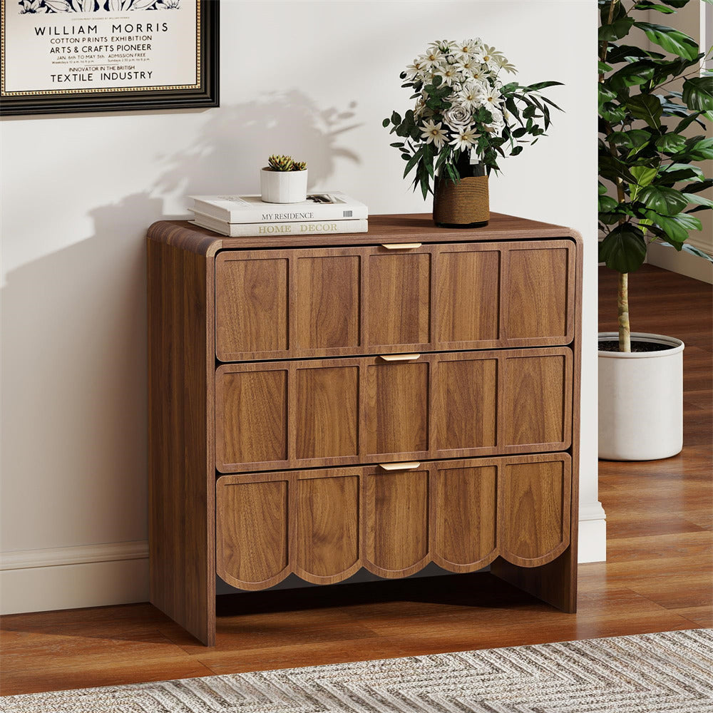 Wooden dresser with decorative items in a room with plants and a framed picture on the wall.