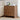 Wooden side table with three drawers in a living room setting.