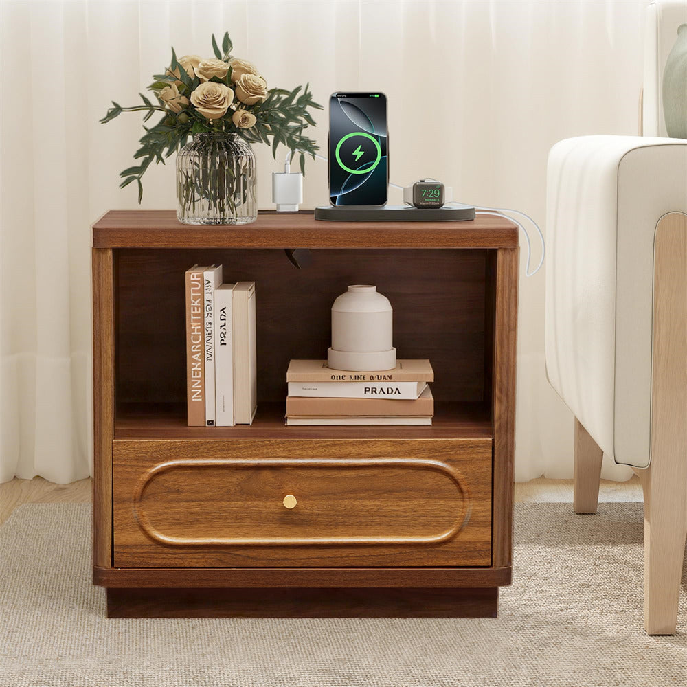 Wooden nightstand with books, a vase of flowers, and electronic devices on a neutral background