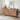 Wooden sideboard with decorative items in a room with a white brick wall.