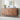 Wooden sideboard with decorative items against a white brick wall.