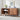 Wooden sideboard with decorative items in a room with a white tiled wall.