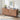 Wooden cabinet with a patterned design on a wooden floor, featuring decor items and a framed picture.