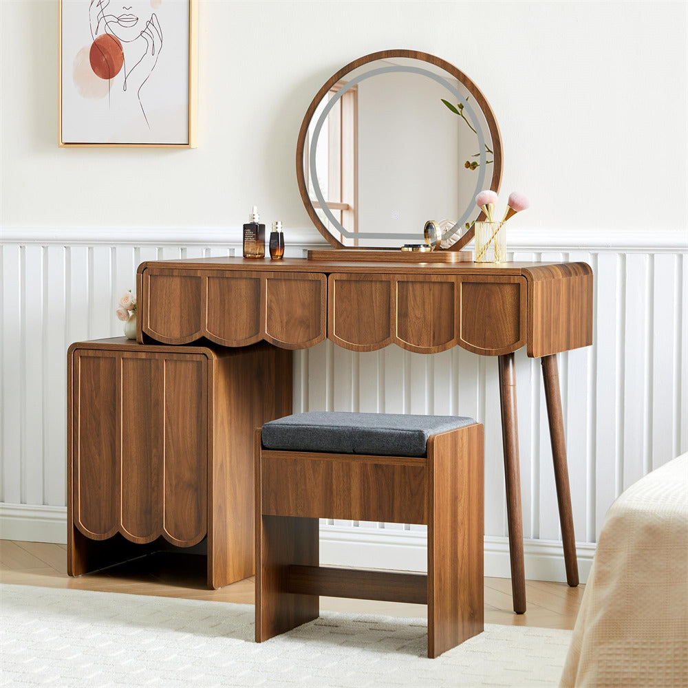 Wooden vanity table with round mirror and stool in a room setting.