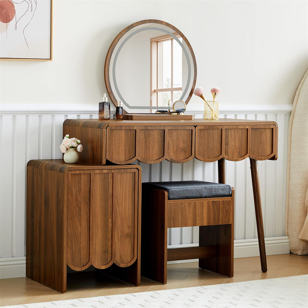 Wooden vanity table with round mirror and stool in a room setting.