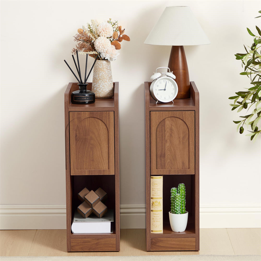 Two wooden side tables with decorative items against a white wall.