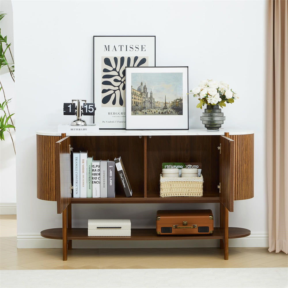 Wooden shelf with books, a suitcase, and decorative items in a room with a plant and framed pictures on the wall.
