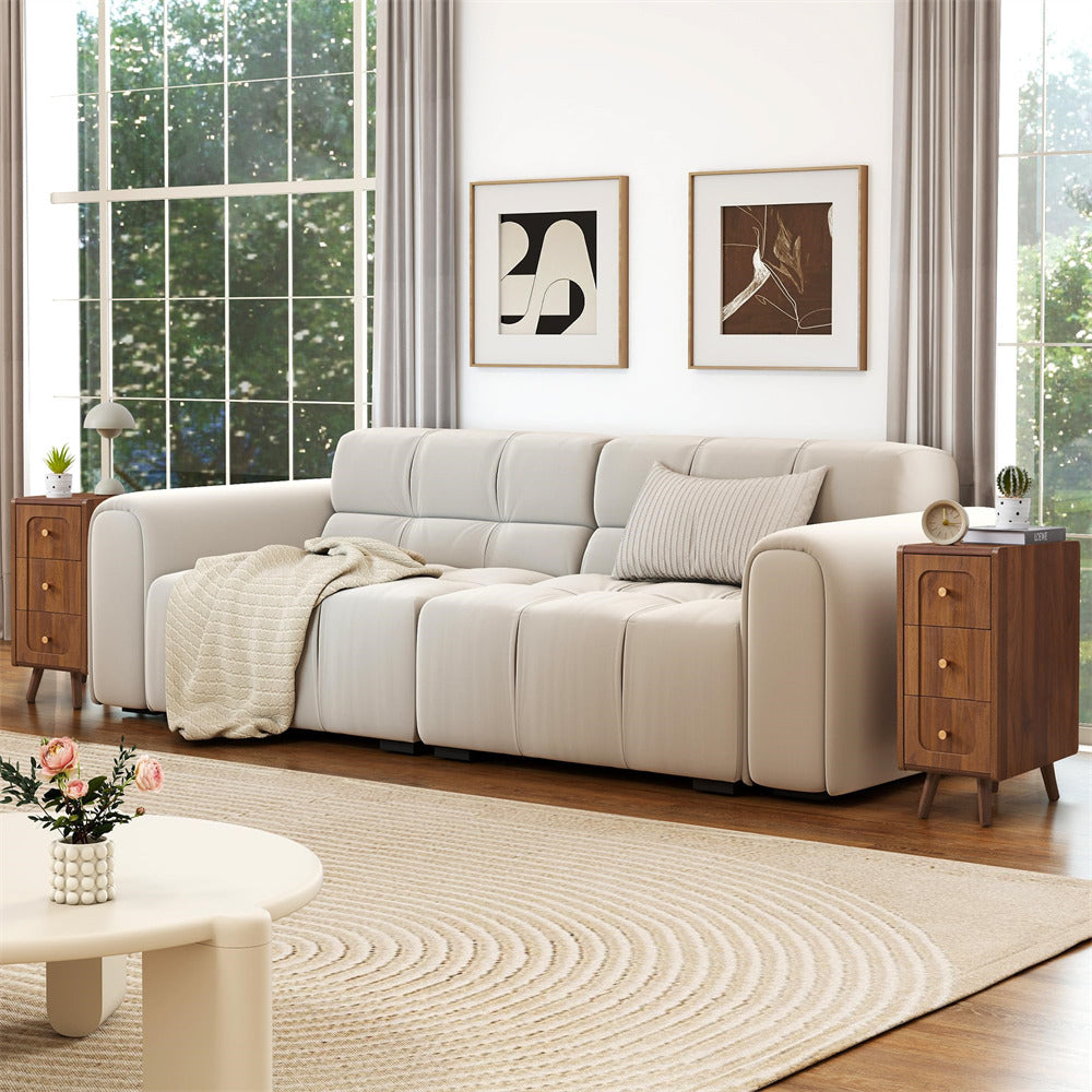 Beige sectional sofa in a living room with wooden side tables and abstract art on the wall.