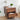 Wooden walnut nightstand with floral carvings, lamp, and books in a room setting.