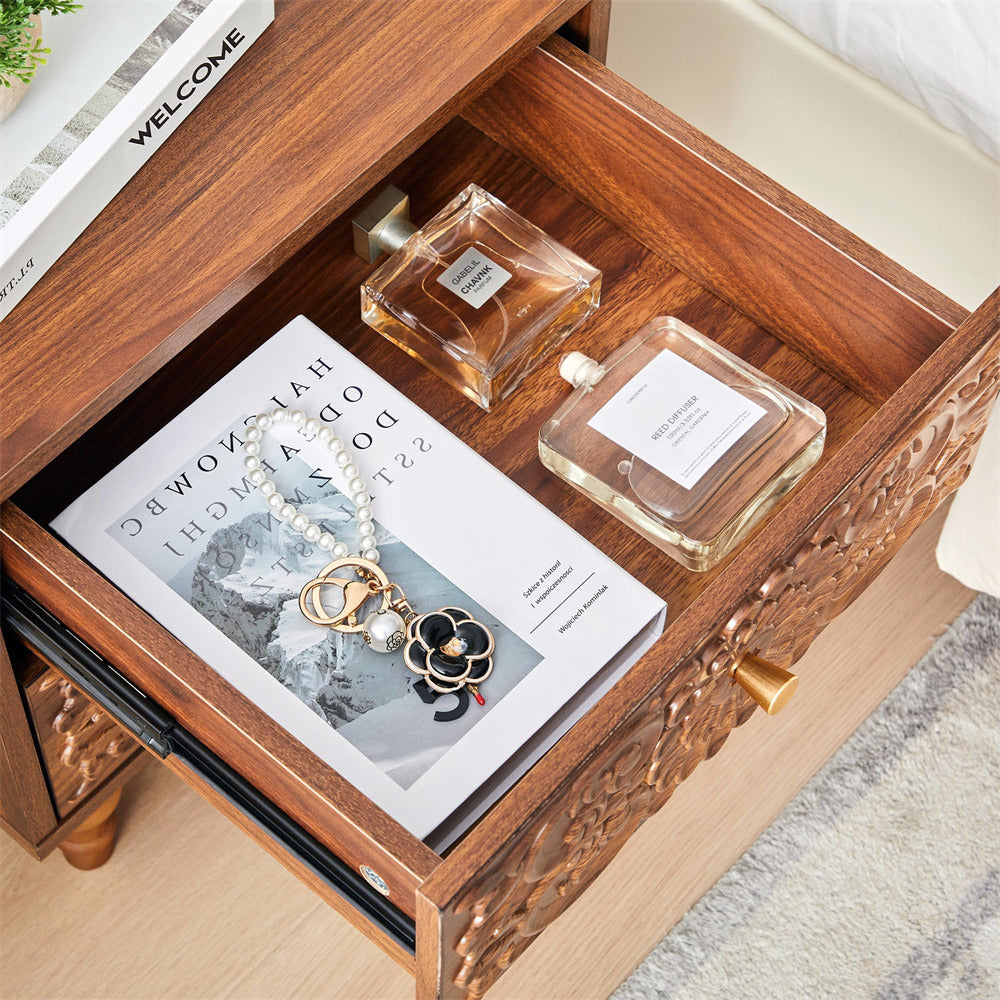 Wooden walnut drawer with a book, necklace, and two perfume bottles on a wooden surface.