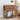Wooden nightstand with floral arrangement and books in a bedroom setting
