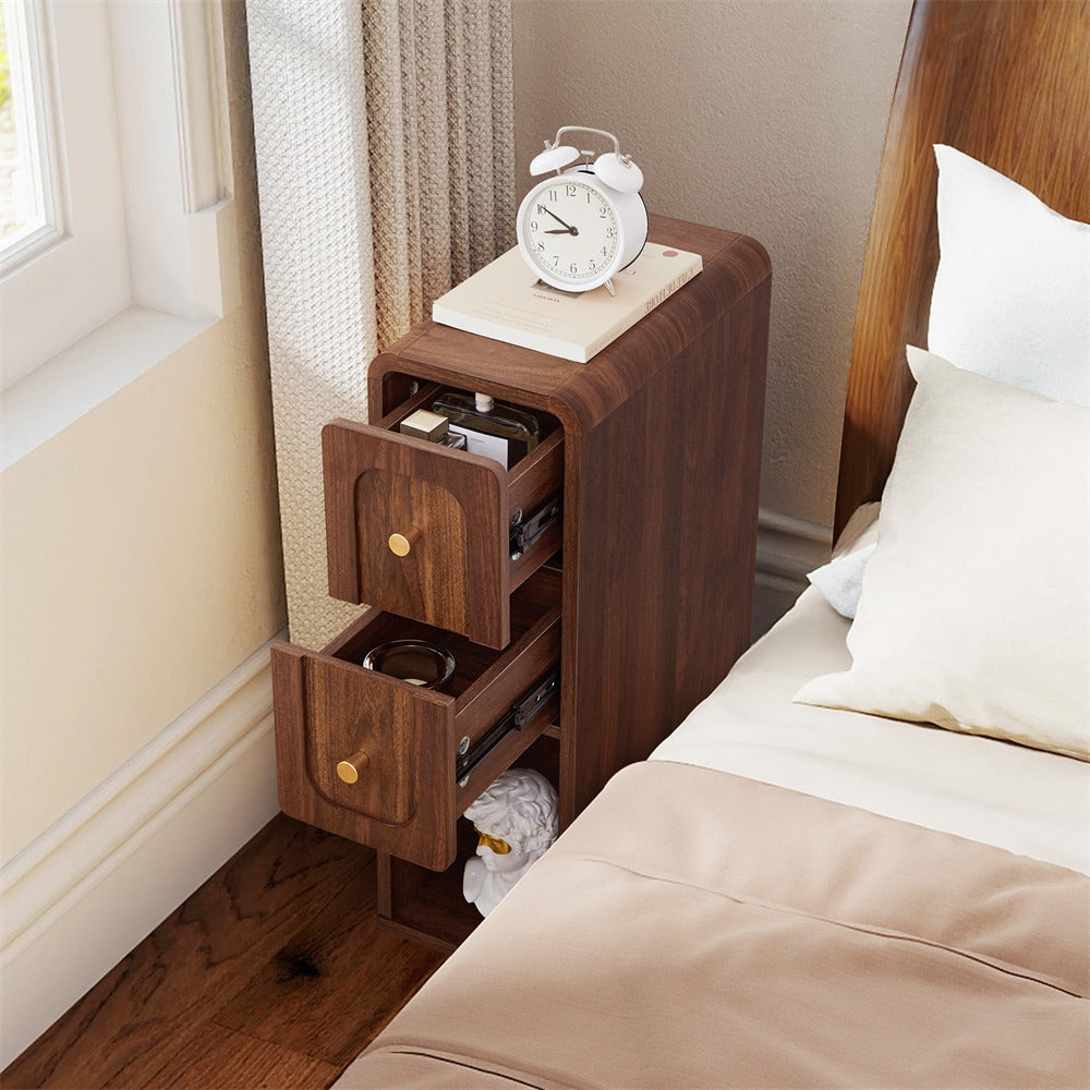 Wooden nightstand with open drawer next to a bed in a bedroom.