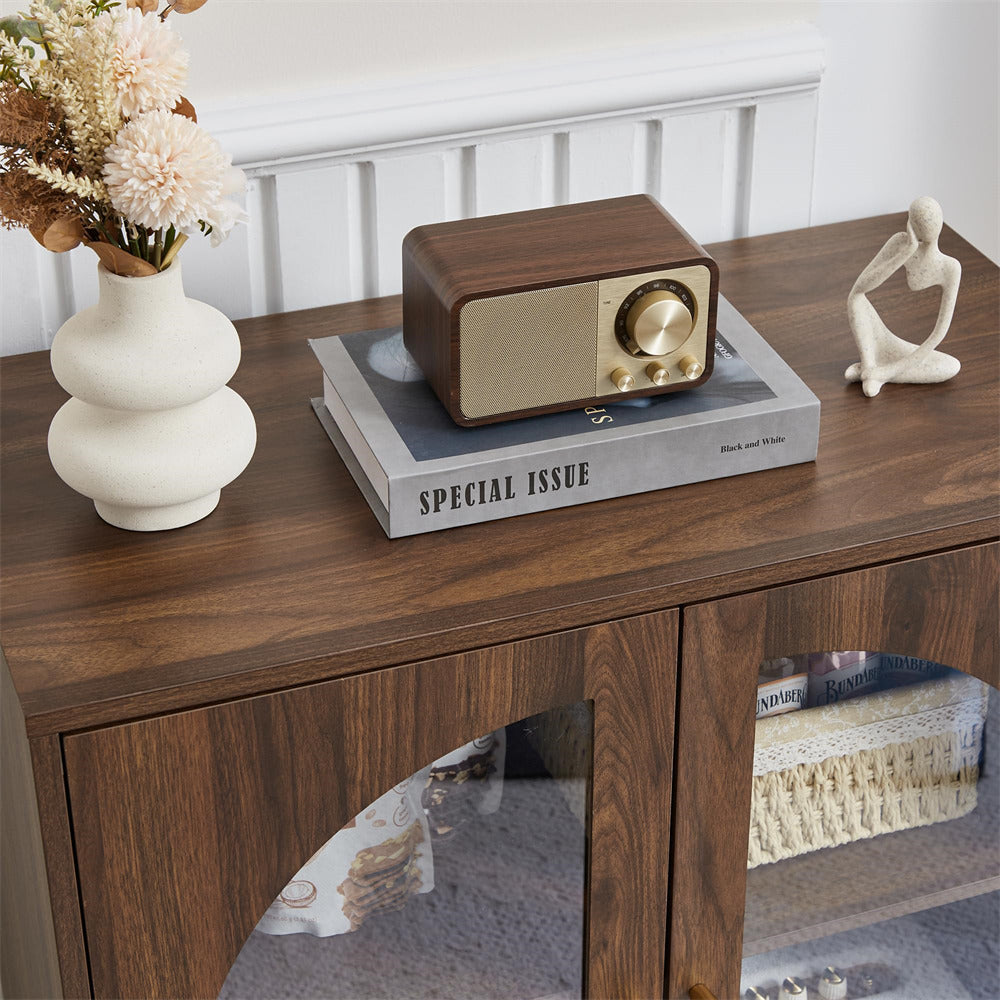 Wooden sideboard with decorative items including a radio, vase, and book.
