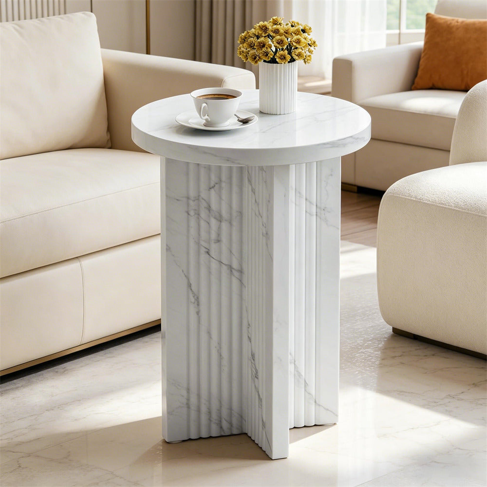 Round marble side table with a cup and flowers in a living room setting