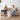 Two women sitting on a couch in a living room, holding cups and smiling.