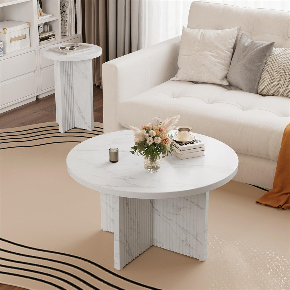 Round marble coffee table in a living room setting with a couch and decorative items.