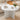 Round marble coffee table with decorative items in a living room setting
