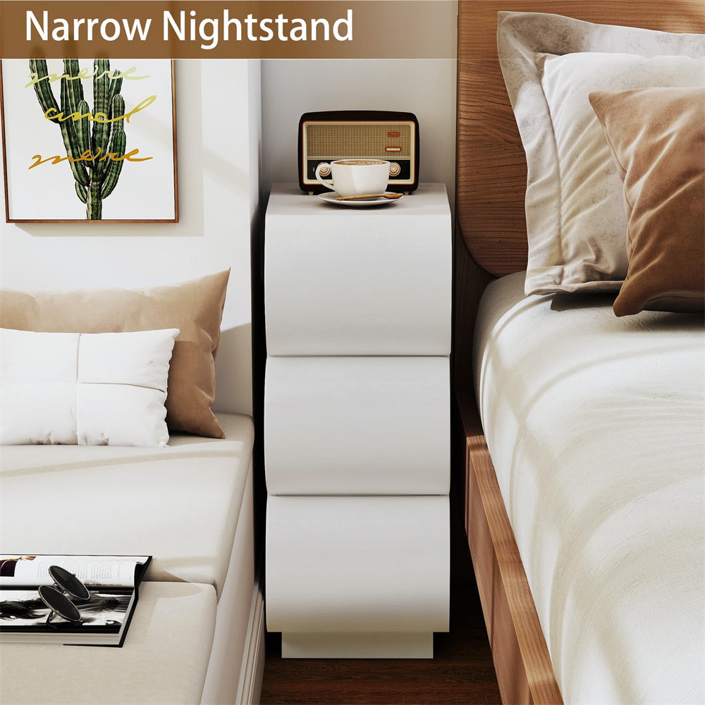 Narrow nightstand between a bed and a sofa in a bedroom setting.