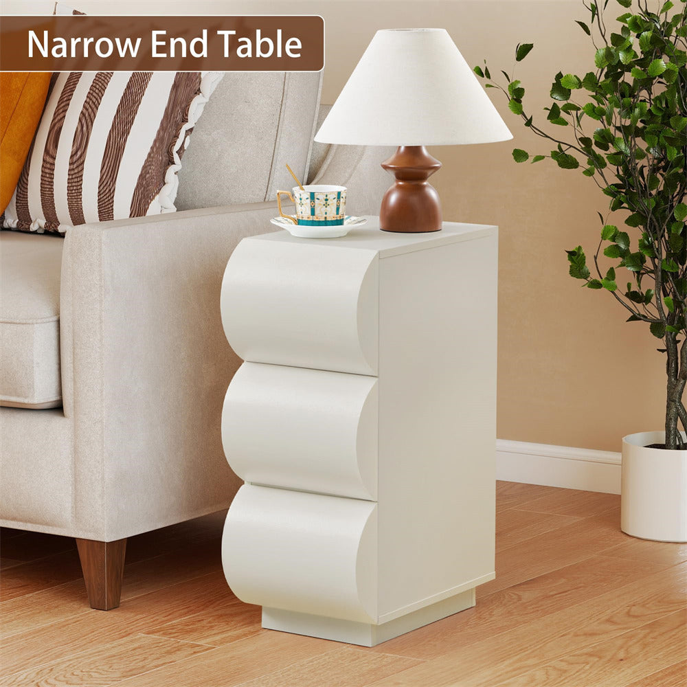 White narrow end table with lamp and cup in a living room setting
