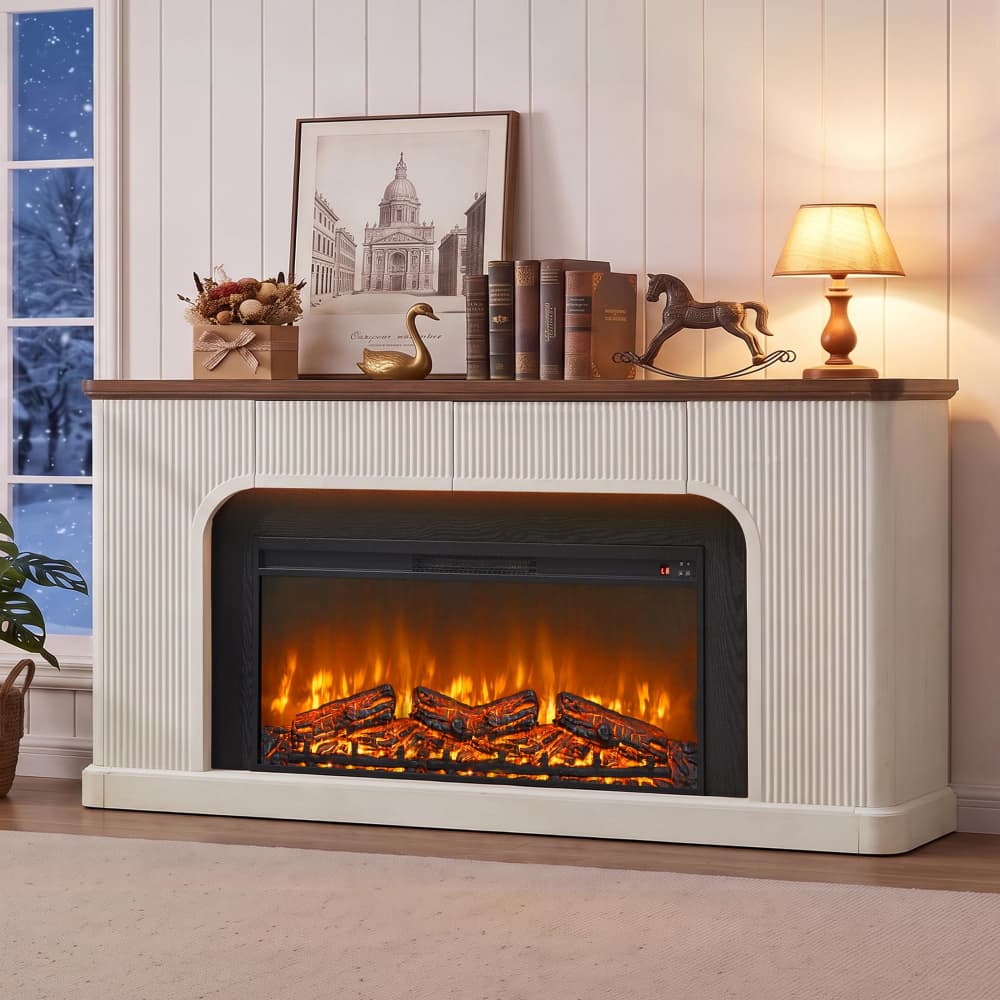 An electric fireplace insert styled in a cozy living room setting. The fireplace has a cream-colored fluted cabinet with a dark wood mantel, displaying glowing orange flames and realistic logs.