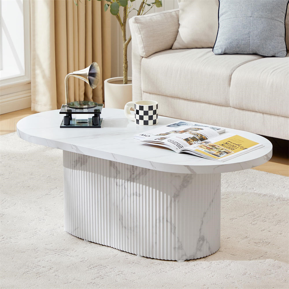 White marble coffee table in a living room setting with magazines and a cup.