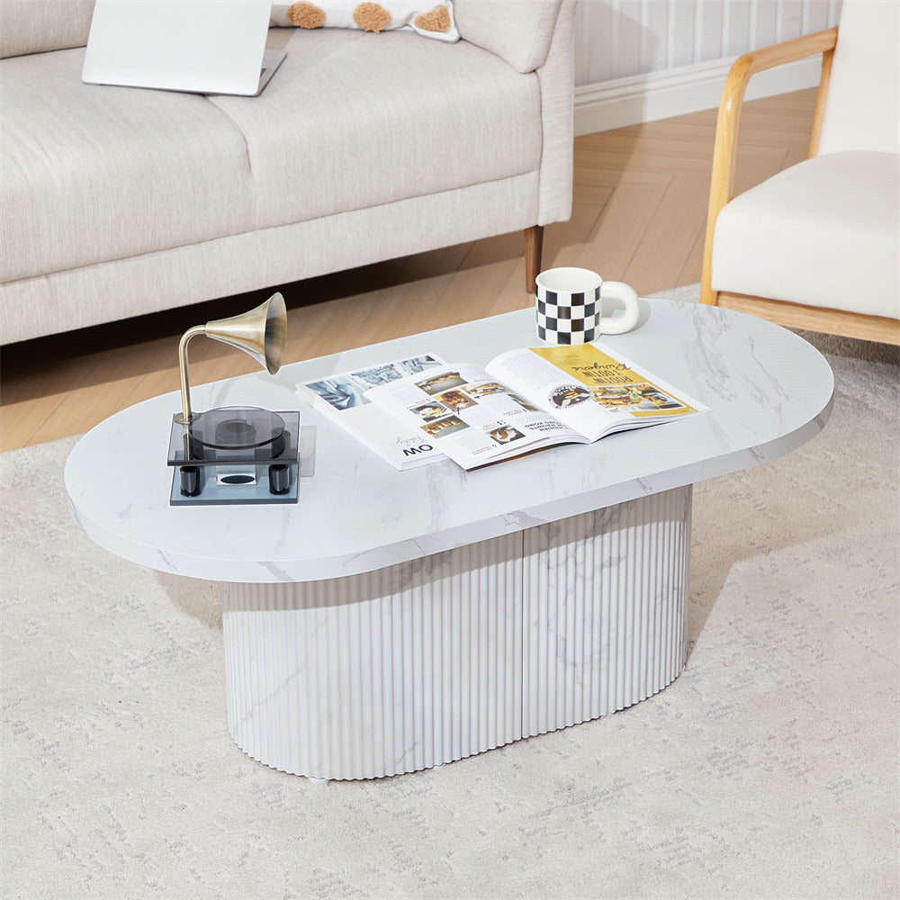 White marble coffee table with magazines and a candle in a living room setting.
